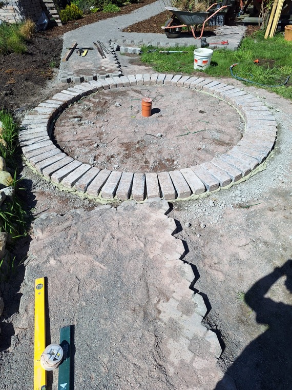 Runde Steineinfassung und Gartenwege während der Bauarbeiten